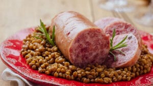Italian large pork sausage cotechino served  with lentils with r